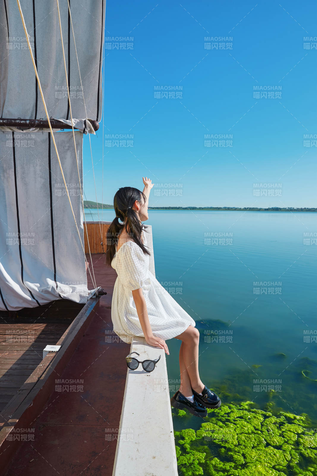 在湖畔木制帆船上的亚洲美女