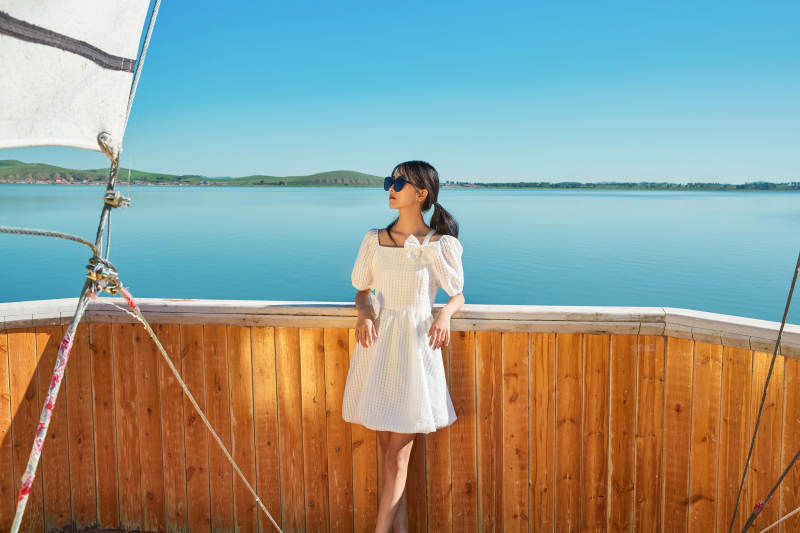 在湖畔木制帆船上的亚洲美女