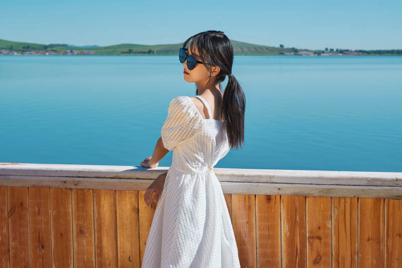 在湖畔木制帆船上的亚洲美女