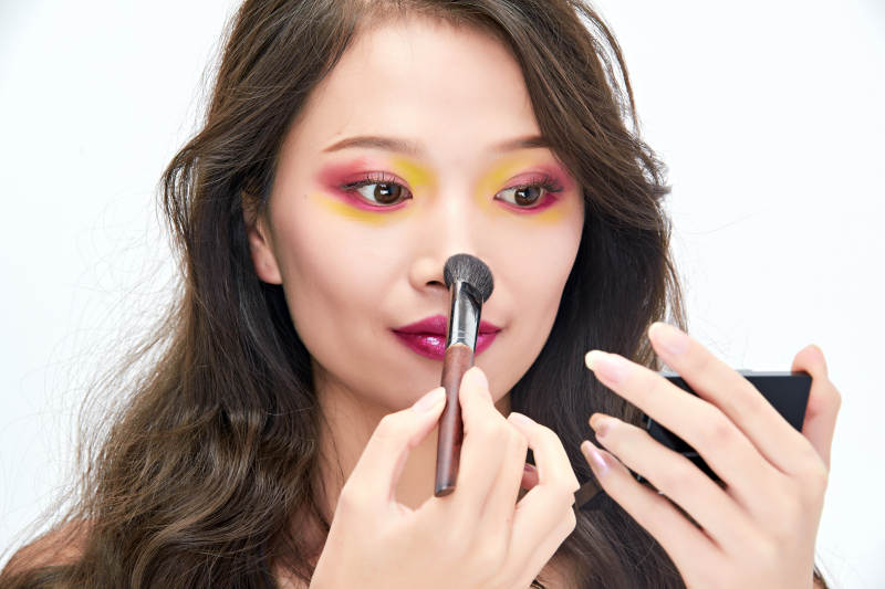 白色背景下棚拍化妆中的美女