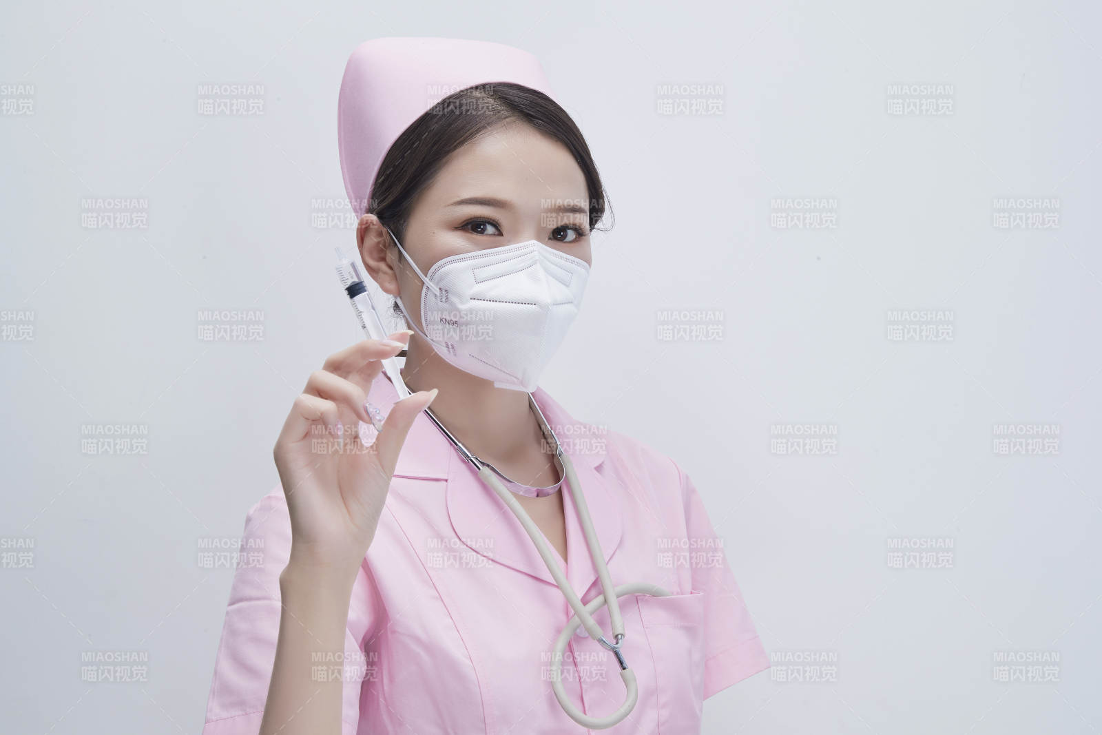 穿护士服戴听诊器口罩手执针筒的年轻女护士