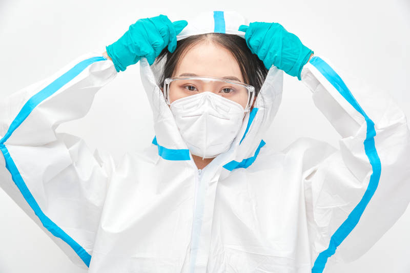 穿白色防護服佩戴護目鏡口罩的女性醫療人員