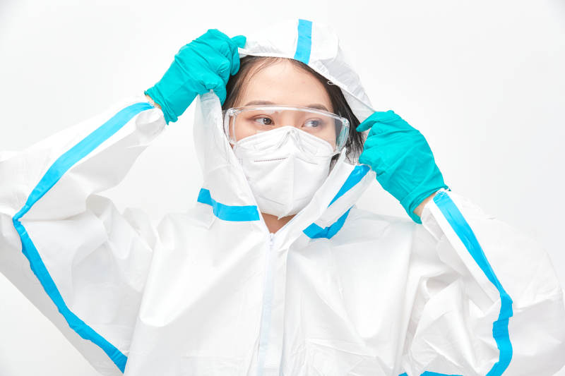 穿白色防護服佩戴護目鏡口罩的女性醫療人員