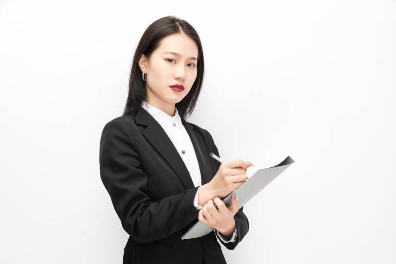 身穿西服拿着文件夹的美丽商务女士