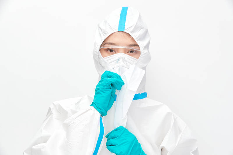 穿白色防护服佩戴护目镜口罩的女性医疗人员