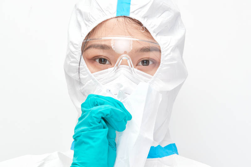 穿白色防護服佩戴護目鏡口罩的女性醫療人員