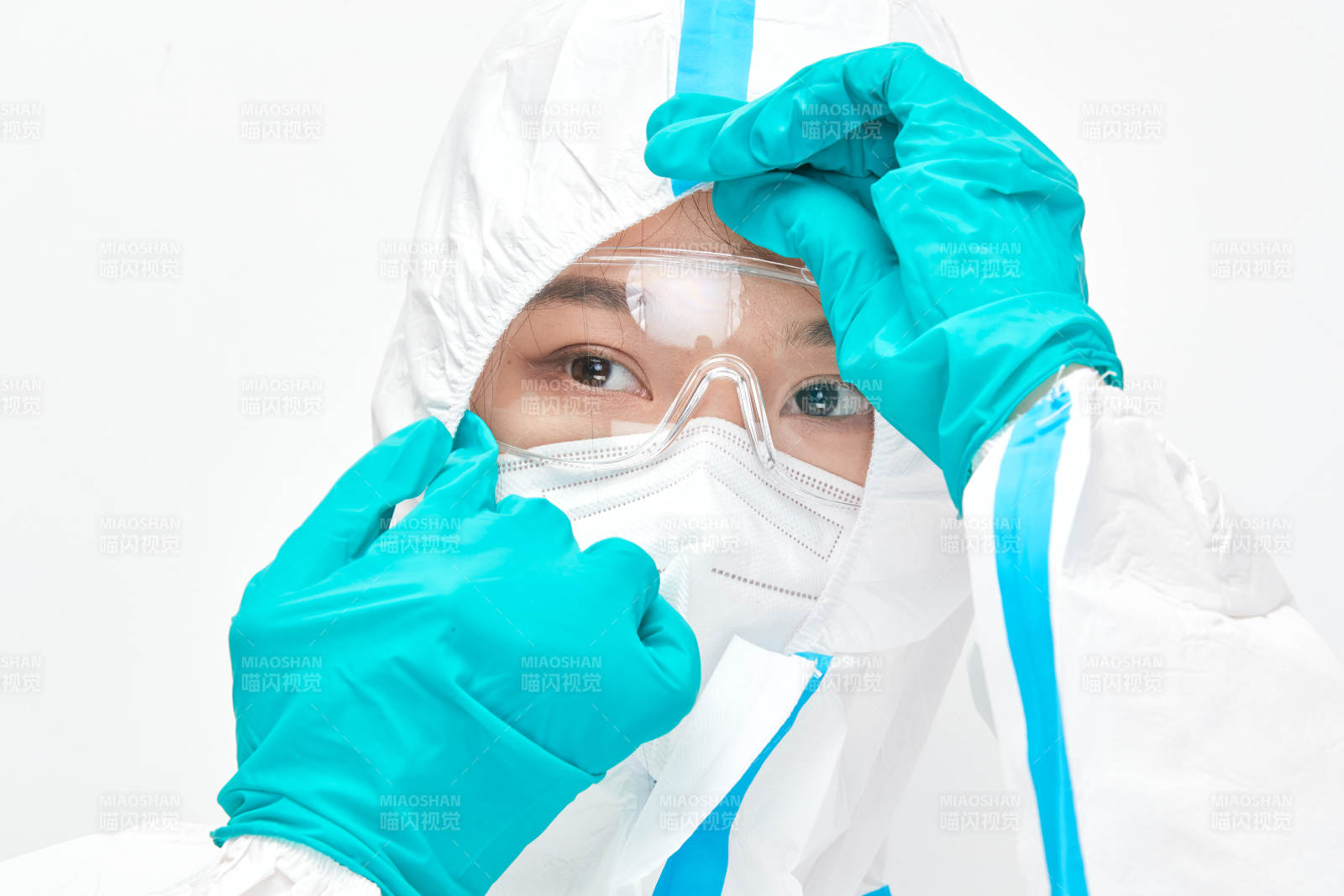 穿白色防護(hù)服佩戴護(hù)目鏡口罩的女性醫(yī)療人員