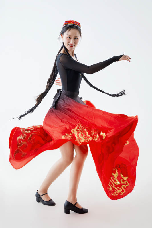 穿着新疆维吾尔族服饰跳舞的少女