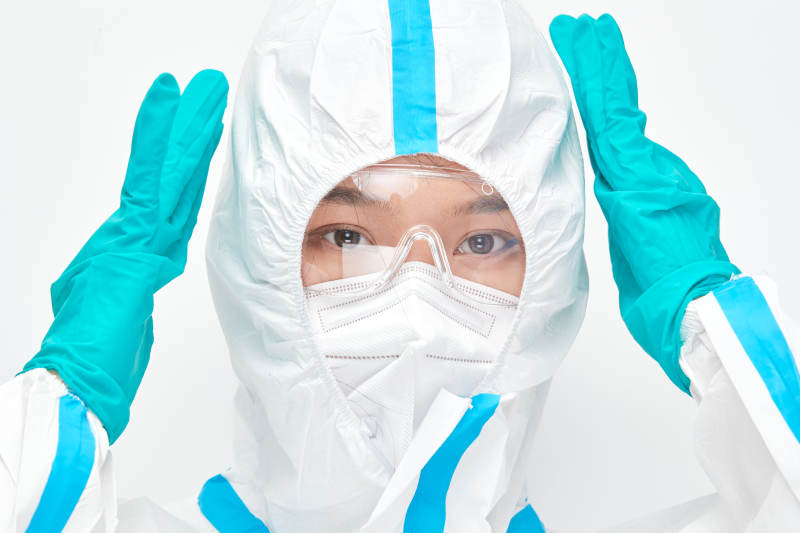 穿白色防护服佩戴护目镜口罩的女性医疗人员