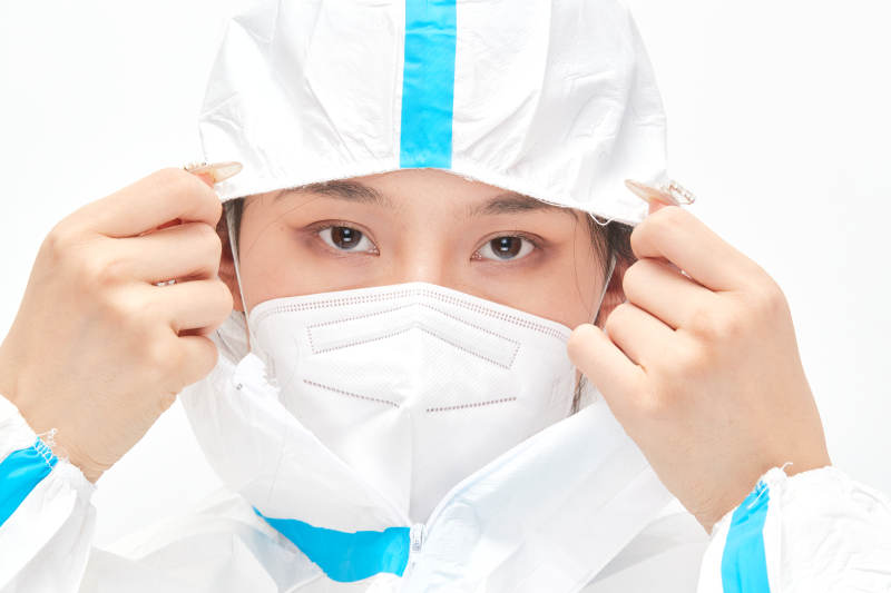 穿白色防护服佩戴护目镜口罩的女性医疗人员