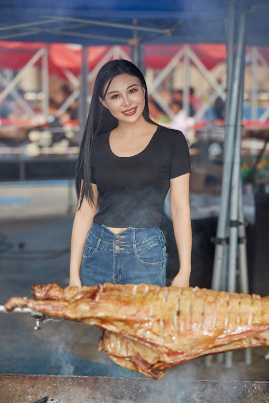 在户外烤全羊自助餐会品尝美食的美女