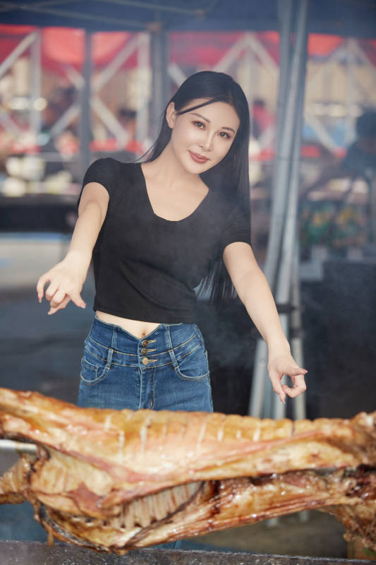 在户外烤全羊自助餐会品尝美食的美女