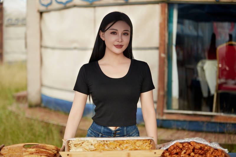 在户外烤全羊自助餐会品尝美食的美女