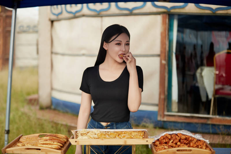 在户外烤全羊自助餐会品尝美食的美女