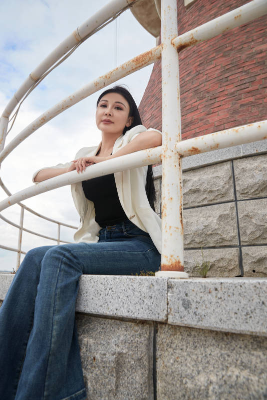 盛夏在景区湖边灯塔上拍照游玩的美女