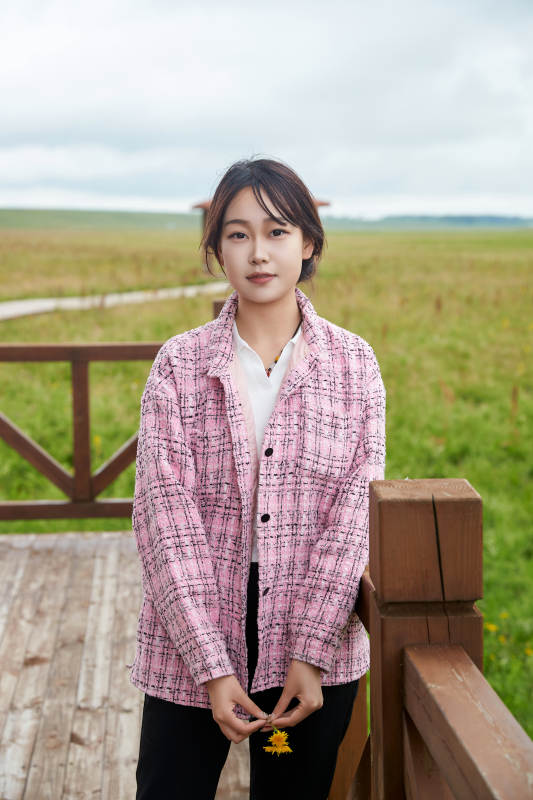 盛夏在草原花海拍照游玩的美女