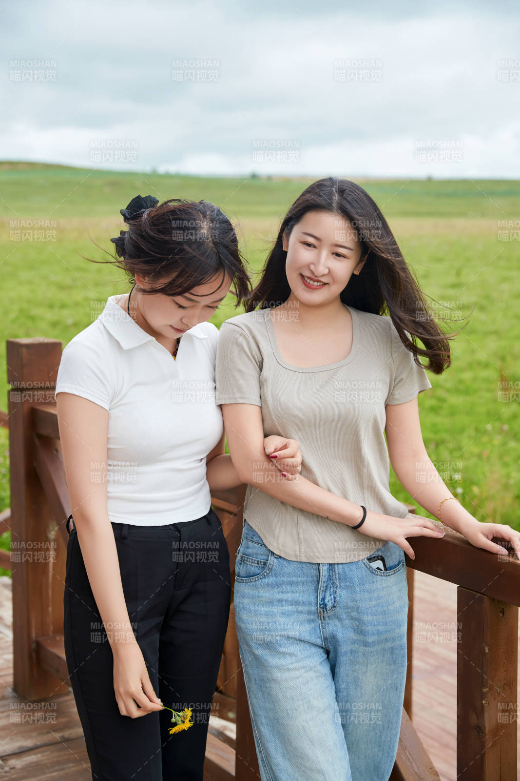 在草原花海观鸟台拍照游玩的美女闺蜜