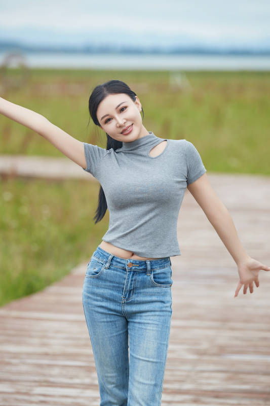 盛夏在草原花海拍照游玩的美女