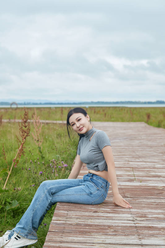 盛夏在草原花海拍照游玩的美女