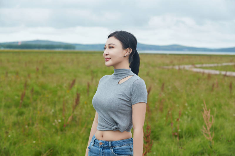 盛夏在草原花海拍照游玩的美女