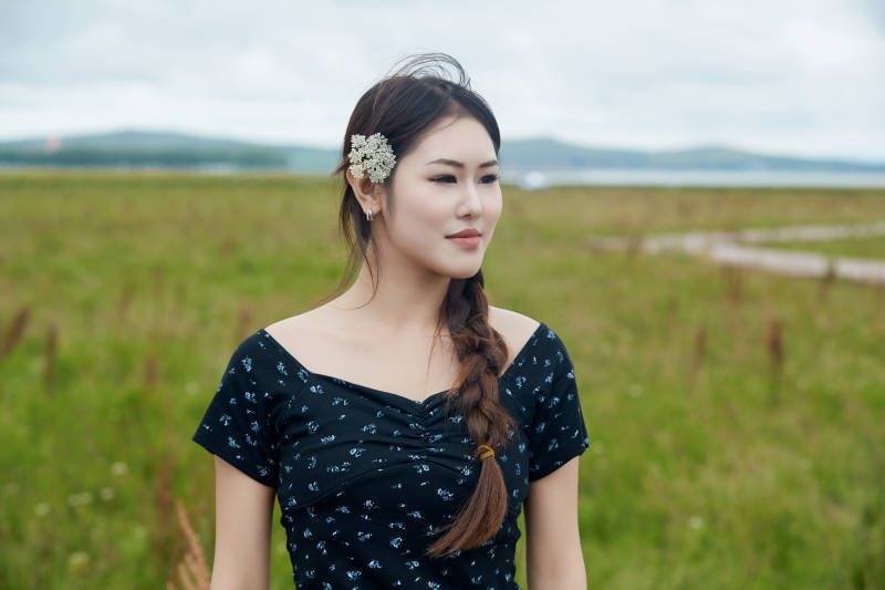 盛夏在草原花海拍照游玩的美女