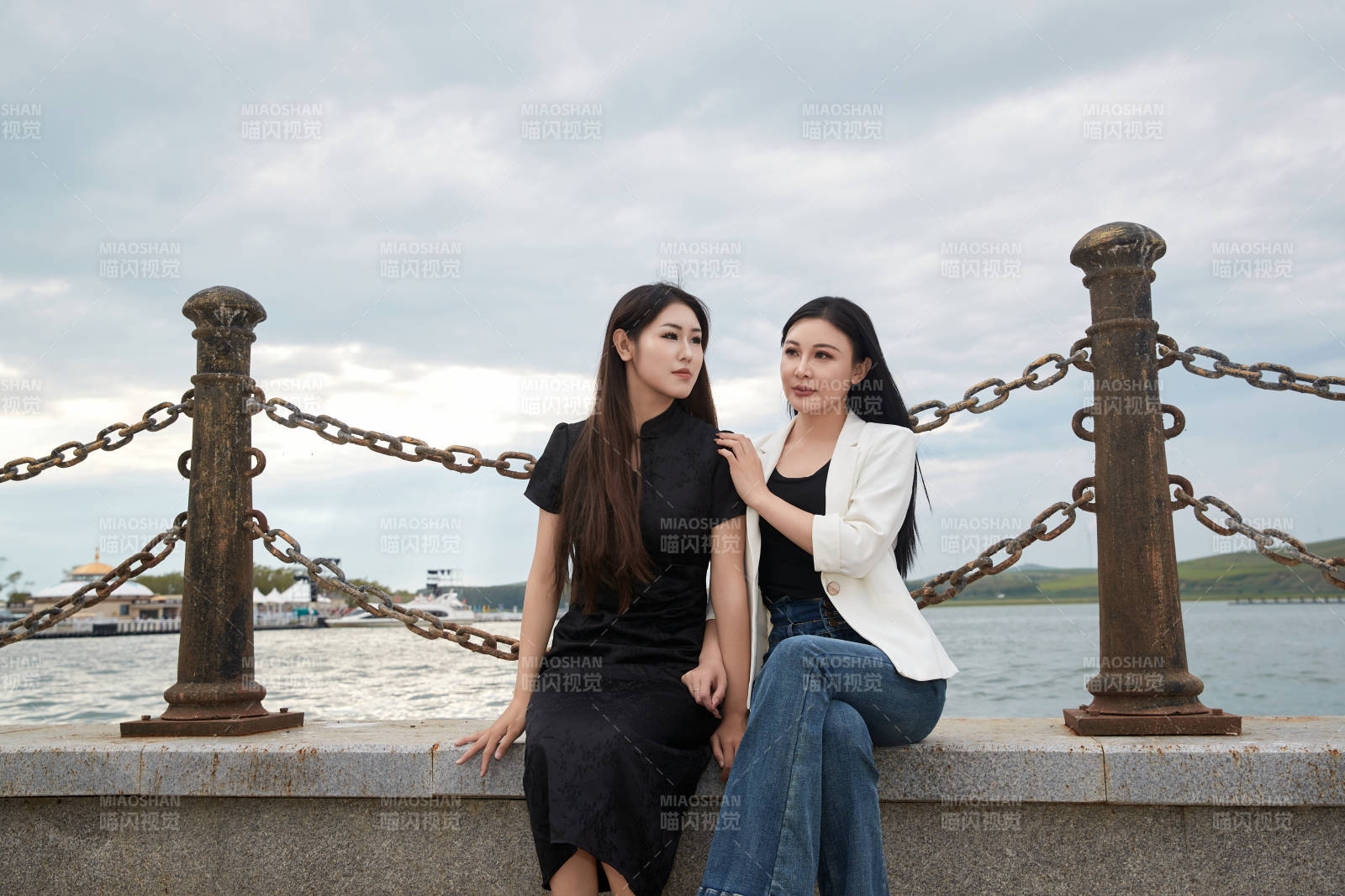 在旅游区湖边打卡点拍照的美女闺蜜