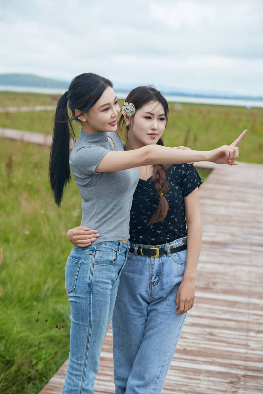 在草原花海观鸟台拍照游玩的美女闺蜜