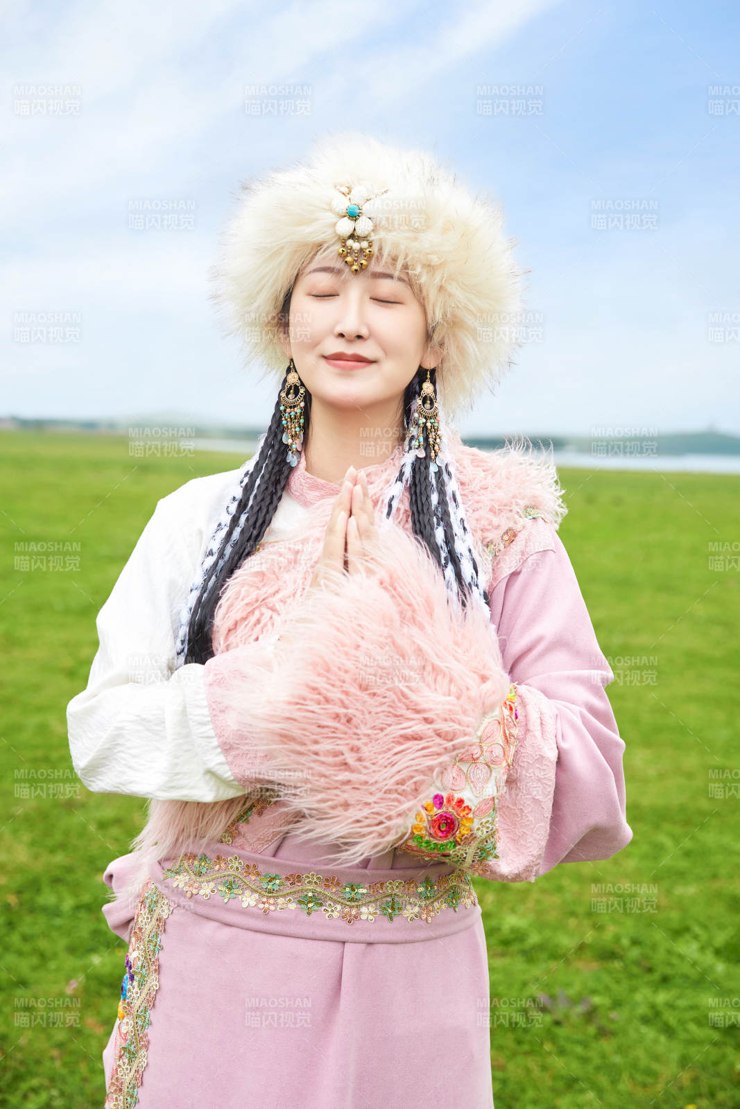 身穿藏族服飾在草原景區拍照的美女