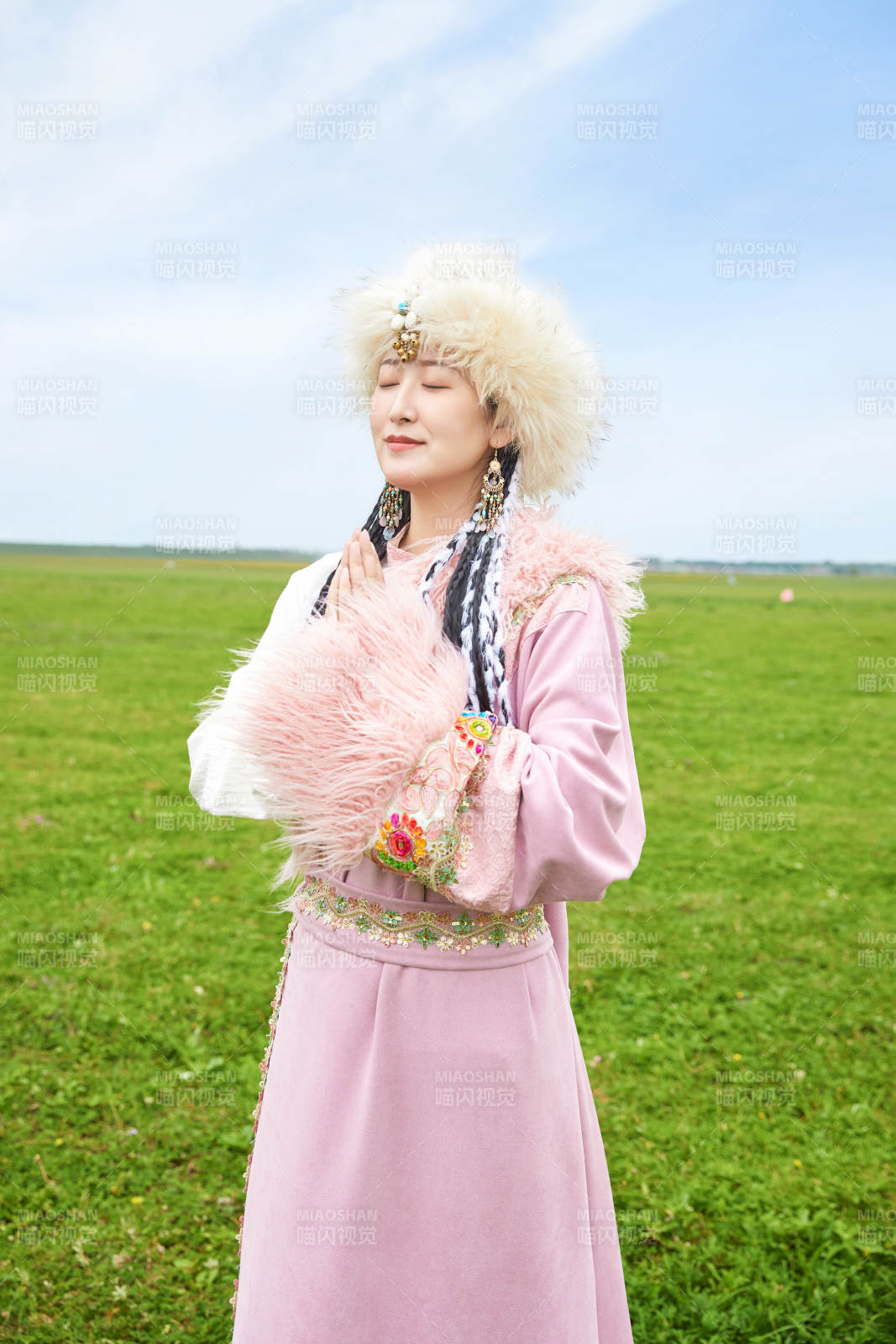 身穿藏族服飾在草原景區(qū)拍照的美女