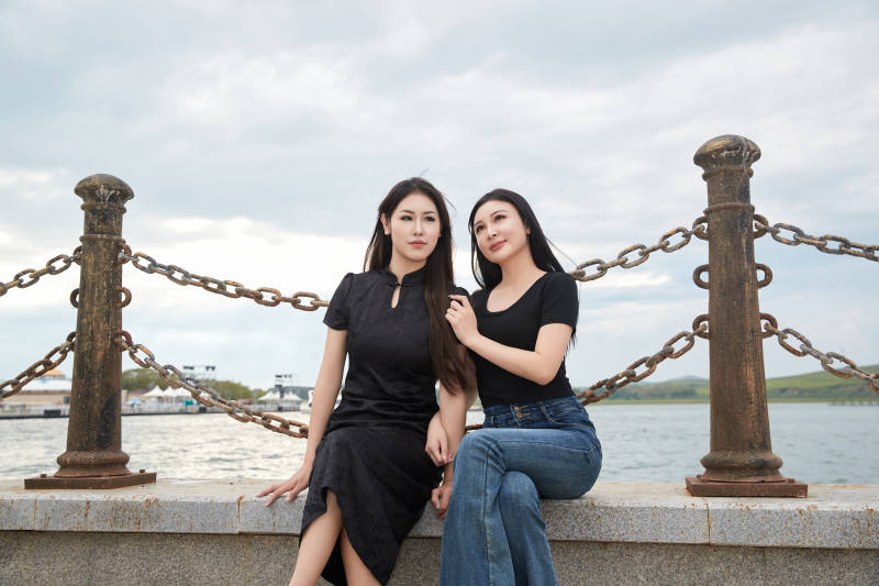 在旅游区湖边打卡点拍照的美女闺蜜