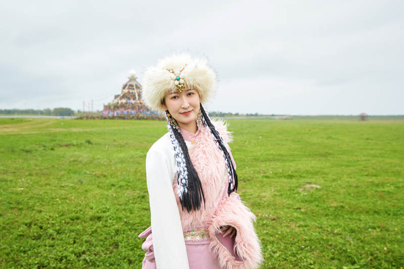 身穿藏族服饰在草原景区拍照的美女
