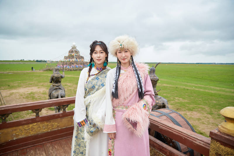身穿藏族服饰在草原拍照游玩的闺蜜