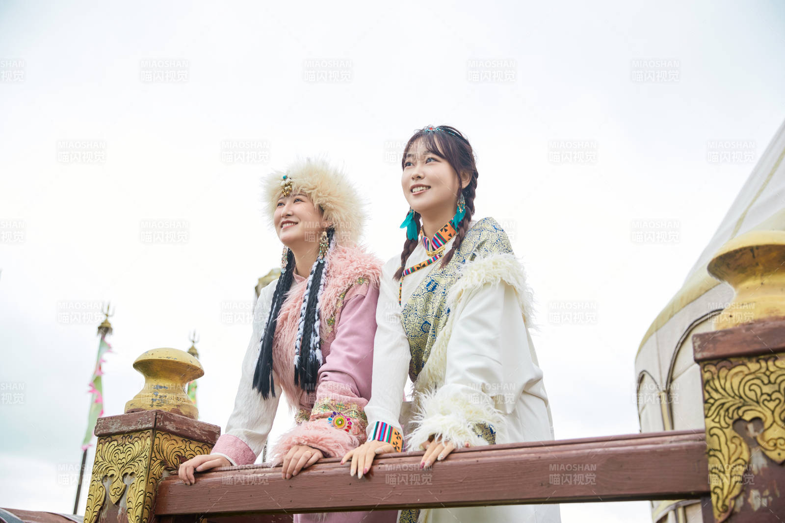 身穿藏族服饰在草原拍照游玩的闺蜜