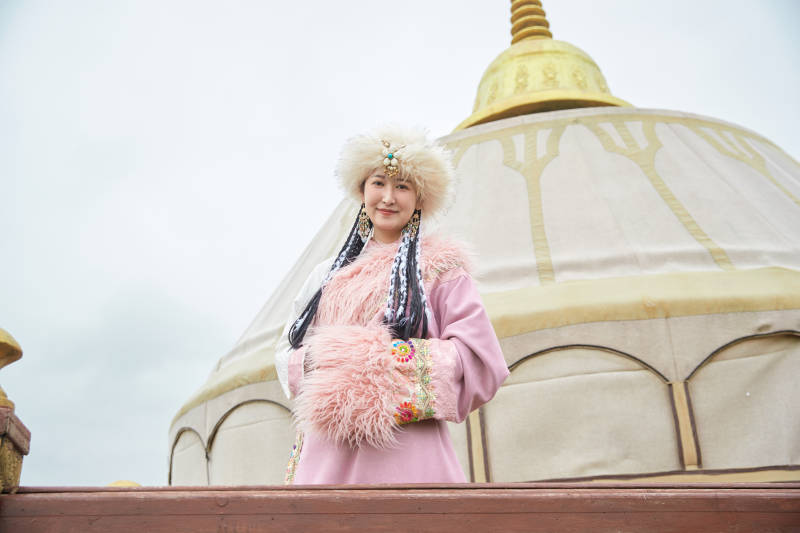 身穿藏族服饰在草原景区拍照的美女