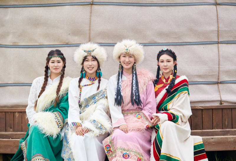 穿藏族服饰在草原拍照游玩的姑娘们