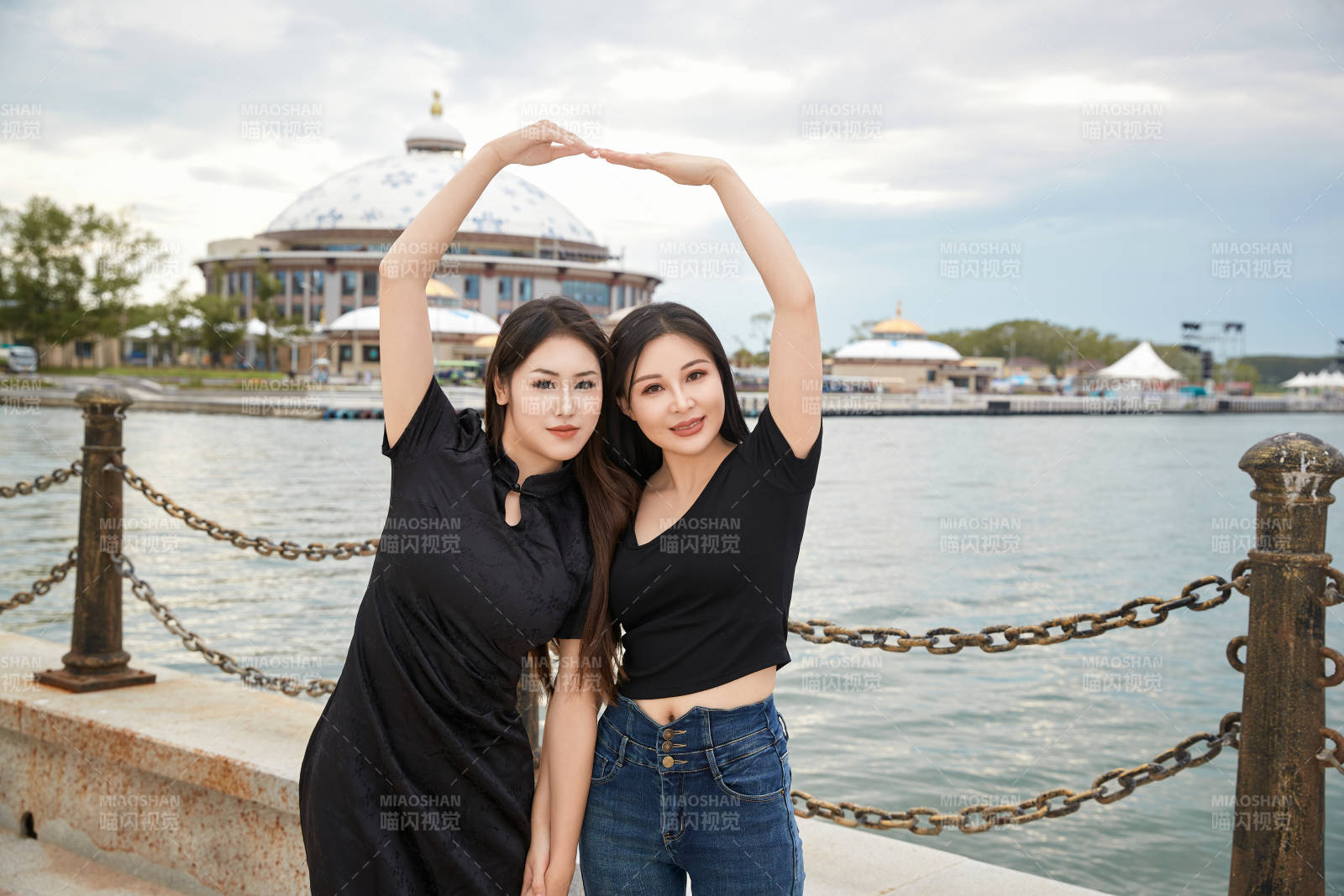 在旅游区湖边打卡点拍照的美女闺蜜