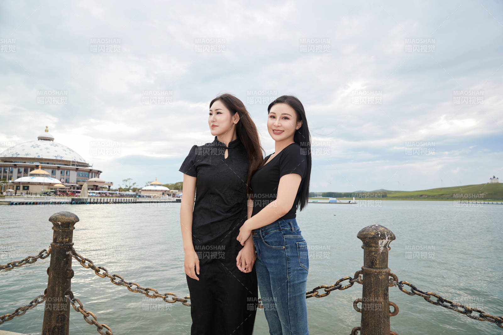 在旅游区湖边打卡点拍照的美女闺蜜