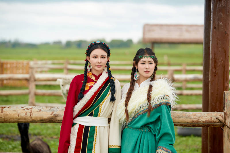 身穿藏族服饰的闺蜜在羊驼饲养基地拍照