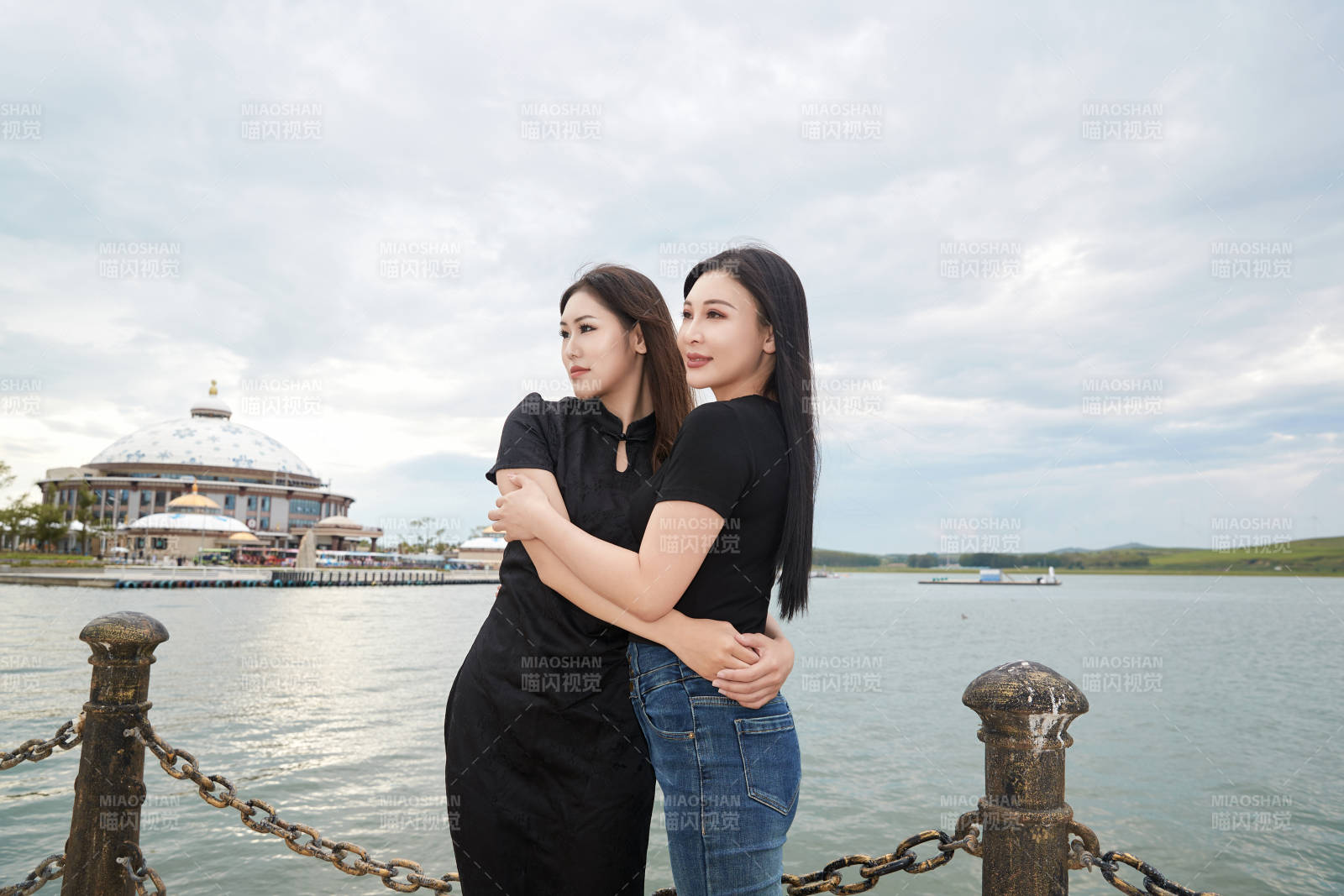 在旅游区湖边打卡点拍照的美女闺蜜