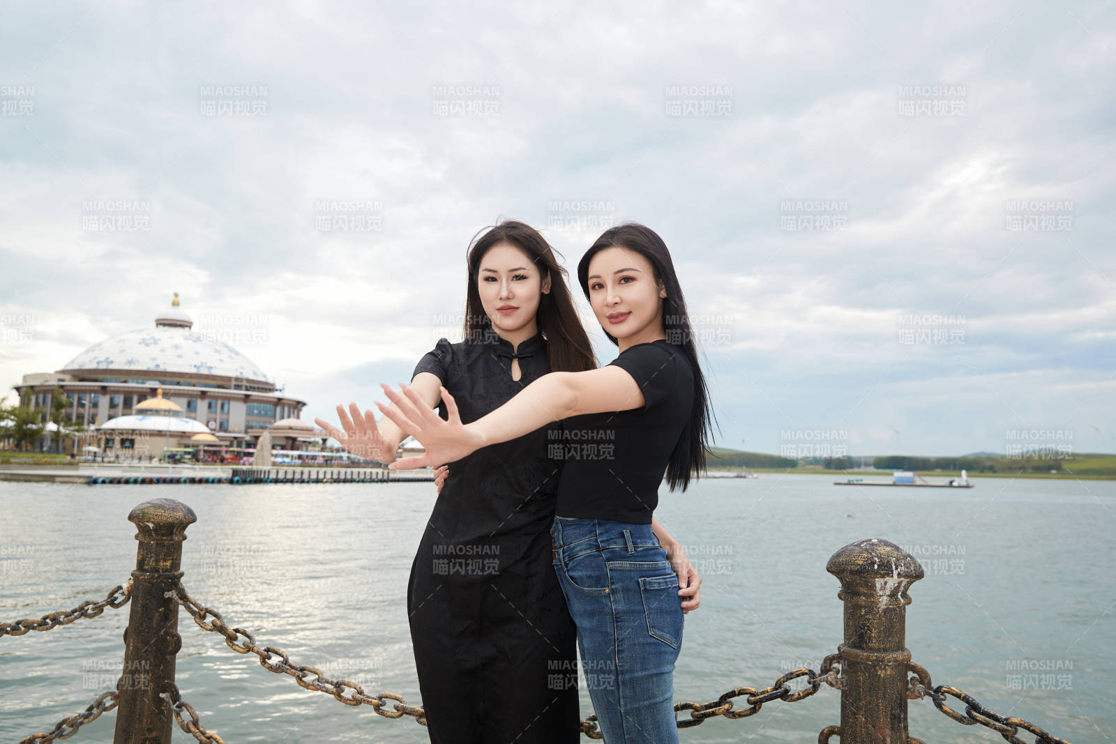 在旅游区湖边打卡点拍照的美女闺蜜