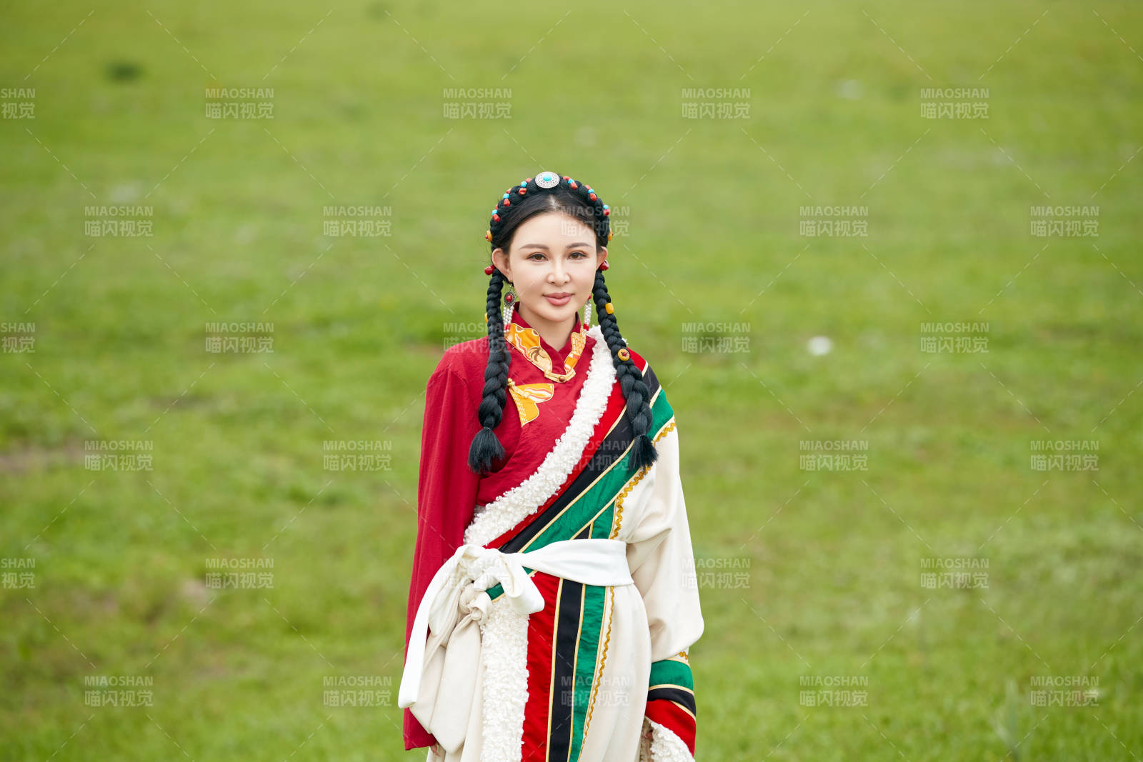 身穿藏族服饰在草原景区拍照的美女