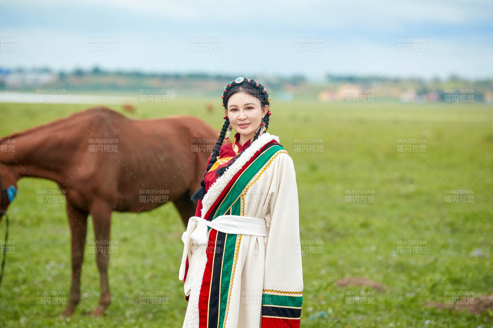 身穿藏族服饰和马匹拍照的美女