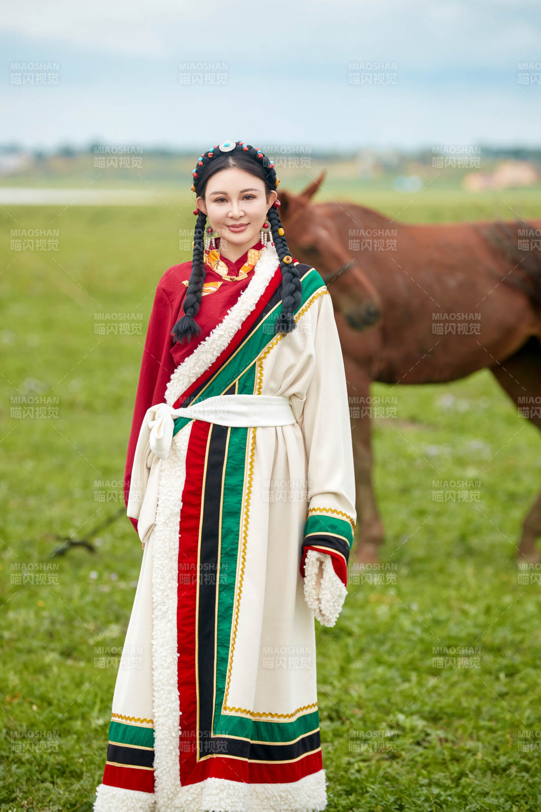 身穿藏族服饰和马匹拍照的美女