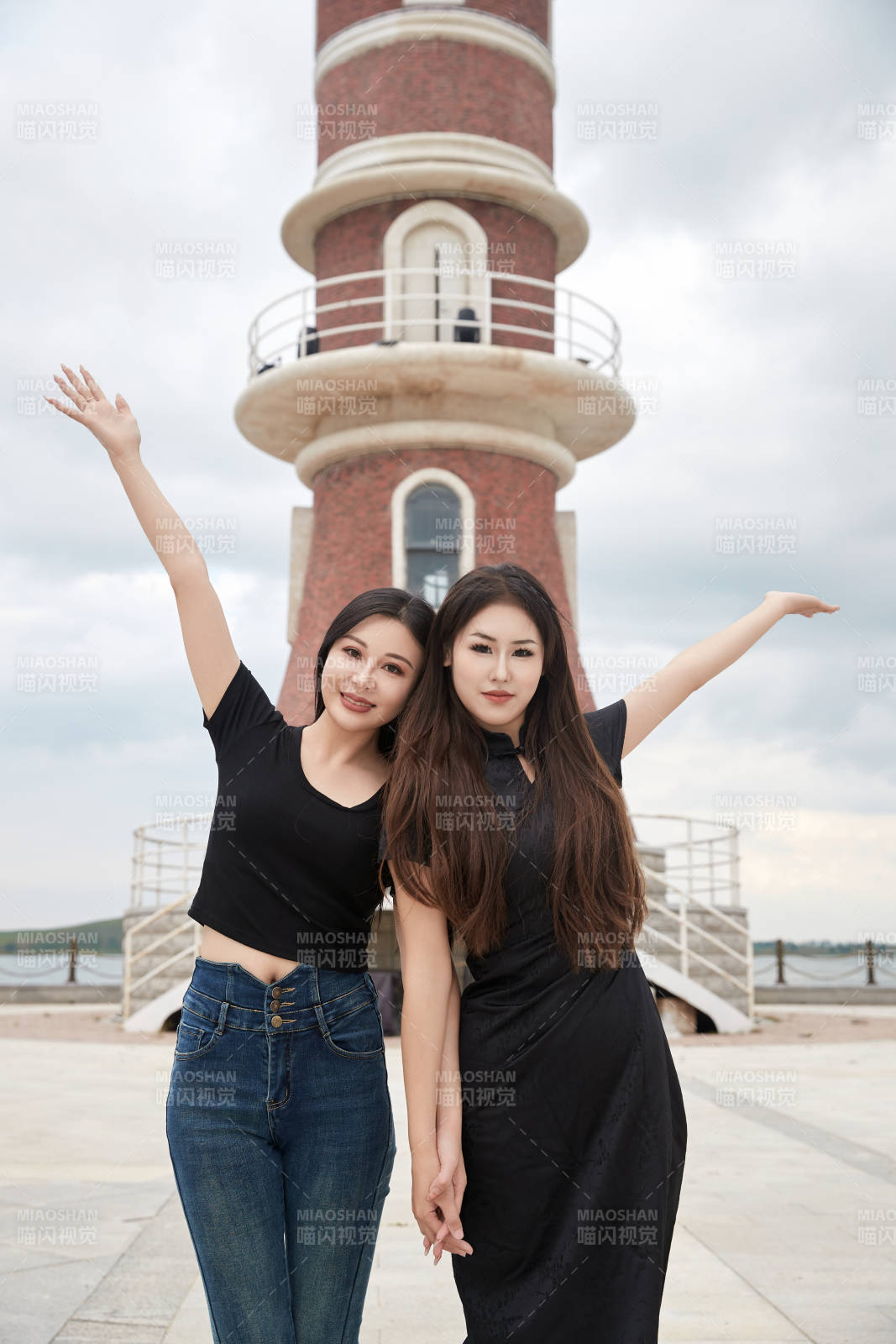 在旅游区湖边打卡点拍照的美女闺蜜