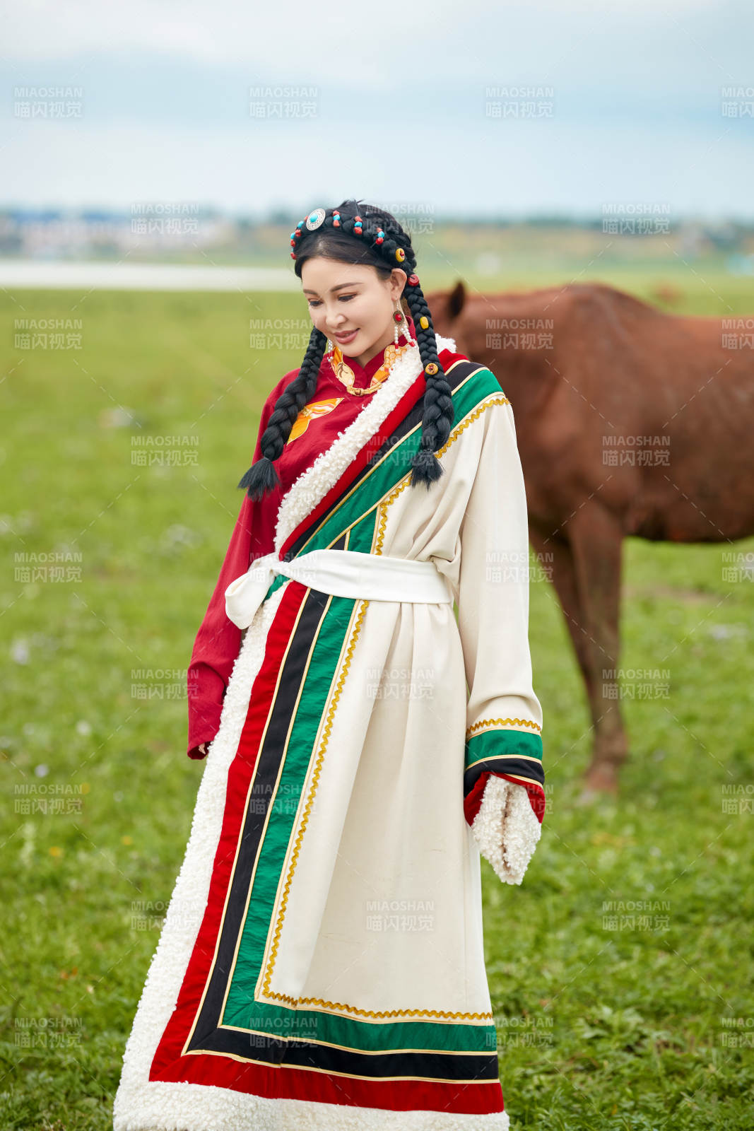 身穿藏族服饰和马匹拍照的美女
