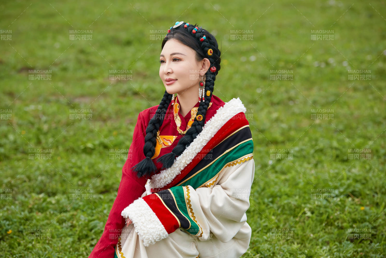 身穿红色藏族服饰在草原景区拍照的美女