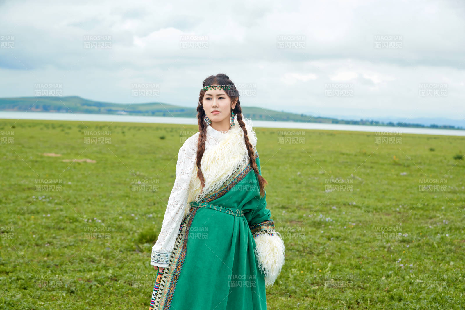 身穿绿色藏族服饰在草原跳舞的美女