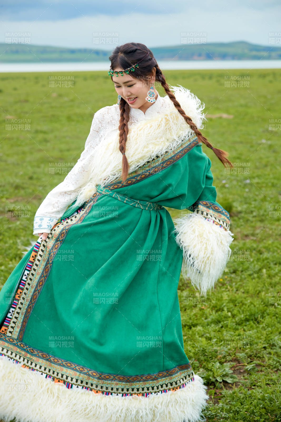 身穿绿色藏族服饰在草原跳舞的美女