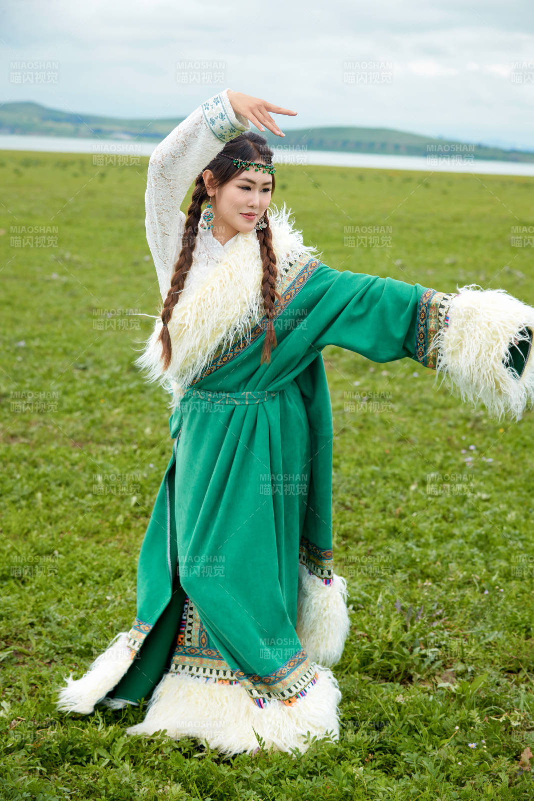 身穿绿色藏族服饰在草原跳舞的美女