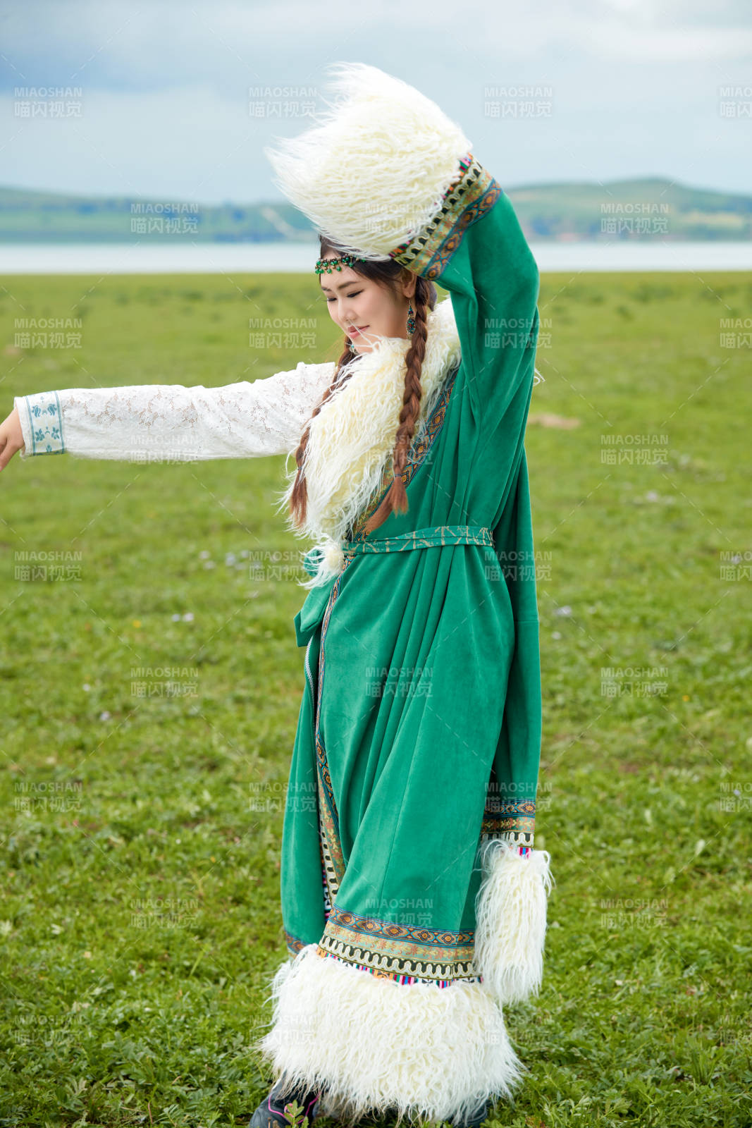 身穿绿色藏族服饰在草原跳舞的美女